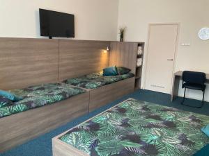 a room with two beds and a flat screen tv at Hotel Poseidon in Scheveningen