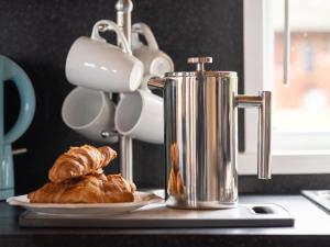 affeepot and a plate of croissants on a counter at Chalet Loch Leven Lodge 4 by Interhome in Kinross