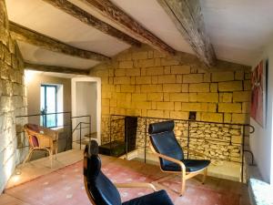 um quarto com duas cadeiras e uma parede de pedra em Holiday Home Cascina ConVista by Interhome em Grazzano Badoglio