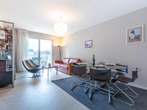 een woonkamer met een tafel en stoelen en een bank bij Apartment Le Galion-2 by Interhome in Dinard