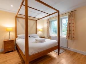 1 dormitorio con cama con dosel y ventana en Holiday Home The Firs by Interhome, en Drumnadrochit