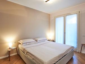 a bedroom with a large bed and a large window at Apartment Promessi Sposi by Interhome in Lecco