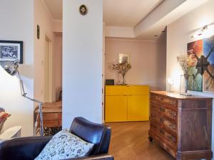 a living room with a black chair and a yellow dresser at Apartment Promessi Sposi by Interhome in Lecco