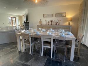 a dining room with a white table and chairs at Le gîte d’Hayen in Sprimont
