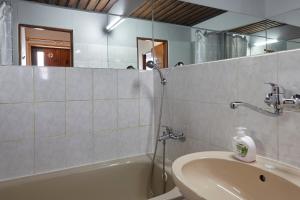 ein Badezimmer mit einer Badewanne, einem Waschbecken und einem Spiegel in der Unterkunft Horská Chata Ještědka in Světlá pod Ještědem