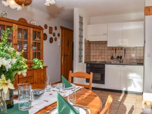 una cucina e una sala da pranzo con tavolo in legno di Apartment Rüthanet by Interhome ad Airolo