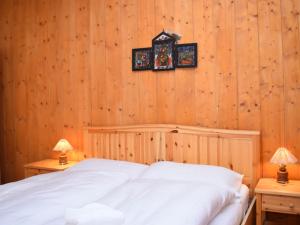 1 dormitorio con 1 cama blanca y 2 lámparas en Apartment Rüthanet by Interhome, en Airolo