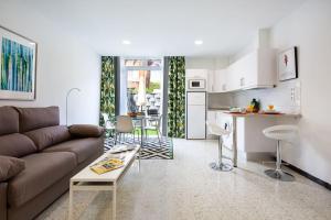 un soggiorno con divano e cucina di Puccini Oasis - Sole e amore a Las Palmas de Gran Canaria