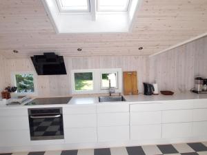 eine Küche mit weißen Schränken und einer Decke mit Fenstern in der Unterkunft Holiday Home Batsha - 350m from the sea in Sealand by Interhome in Tisvildeleje