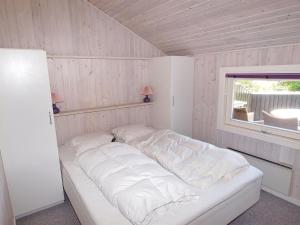 ein großes weißes Bett in einem Zimmer mit Fenster in der Unterkunft Holiday Home Batsha - 350m from the sea in Sealand by Interhome in Tisvildeleje