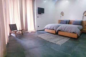 馬拉喀什的住宿－Villa Marrakech，一间卧室配有一张床、一把椅子和电视