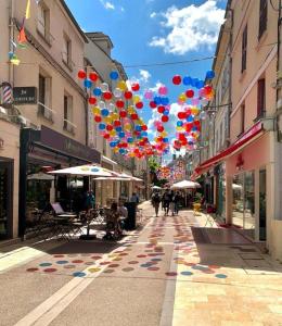 uma rua com balões coloridos pendurados sobre uma rua em Lovely 2 Bedroom House Close to Paris, Airports and Disneyland - LAGNY SUR MARNE em Lagny