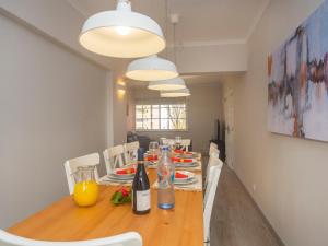 una sala da pranzo con tavolo, sedie e bottiglie di vino di Apartment Olivais by Interhome a Lisbona