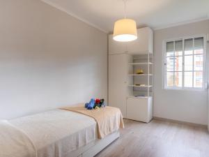 a white bedroom with a bed and a window at Apartment Olivais by Interhome in Lisbon