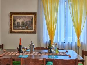a dining room table with wine glasses and a picture at Apartment Mario by Interhome in Dervio