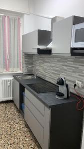 una pequeña cocina con fregadero y microondas en G&A Milan House CIR 03041 en Milán