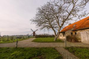 フールネにあるRustic family holiday home for up to 8 people located in the green of the countrysideの納屋と風車