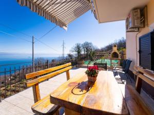- une table en bois sur un balcon avec vue sur l'océan dans l'établissement Apartment Edita by Interhome, à Lovran