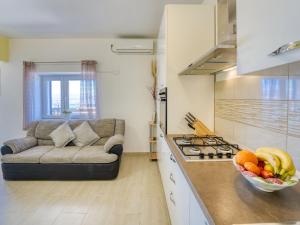 - une cuisine avec un canapé et un bol de fruits sur le comptoir dans l'établissement Apartment Edita by Interhome, à Lovran