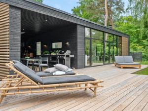 una terraza de madera con tumbona. en Holiday Home Amilia - 1km from the sea in Sealand by Interhome, en Hornbæk