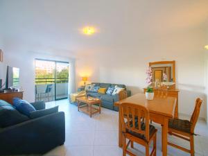 un salon avec un canapé bleu et une table dans l'établissement Apartment Garden Place by Interhome, à Armação de Pêra