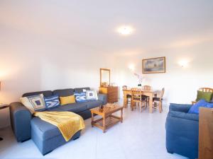 un salon avec un canapé bleu et une table dans l'établissement Apartment Garden Place by Interhome, à Armação de Pêra
