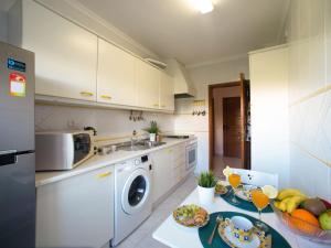une cuisine avec un lave-linge et une table avec des fruits dans l'établissement Apartment Garden Place by Interhome, à Armação de Pêra 19 autres photos
