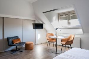 a bedroom with a bed and two chairs and a table at B&B Witvliet, kamers en studio met heerlijk ontbijt ! in Zoutelande