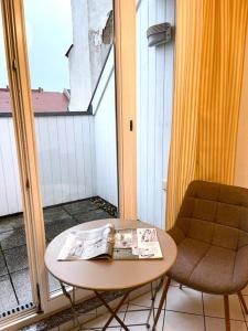 a table and a chair on a balcony with a newspaper at Dachgeschosswohnung mit 2 Schlafzimmern Zentrum Nord mit Aufzug in Leipzig
