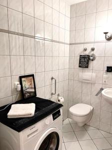a bathroom with a washing machine and a toilet at Dachgeschosswohnung mit 2 Schlafzimmern Zentrum Nord mit Aufzug in Leipzig
