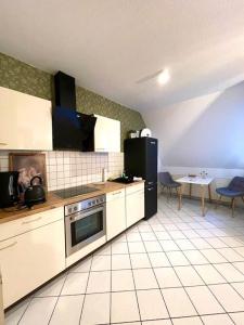 a kitchen with a refrigerator and a table with chairs at Dachgeschosswohnung mit 2 Schlafzimmern Zentrum Nord mit Aufzug in Leipzig