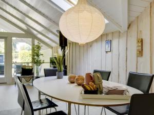 comedor con mesa y lámpara de araña en Holiday Home Liselotta - 550m from the sea in Sealand by Interhome, en Hornbæk