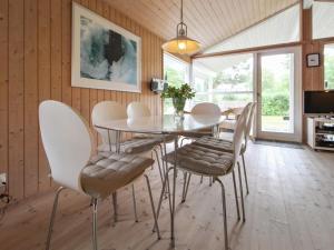 uma sala de jantar com uma mesa de vidro e cadeiras em Holiday Home Fasti - 300m from the sea in Sealand by Interhome em Gilleleje