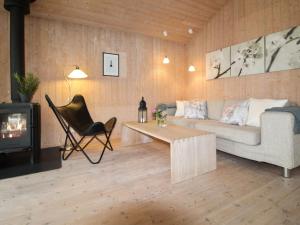 uma sala de estar com um sofá, uma mesa e uma lareira em Holiday Home Fasti - 300m from the sea in Sealand by Interhome em Gilleleje