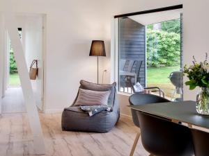 a living room with a chair and a table at Holiday Home Dorthie - 800m from the sea by Interhome in Hornbæk