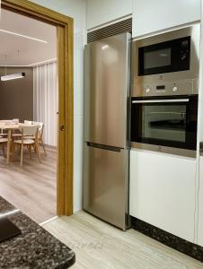 een keuken met een roestvrijstalen koelkast en een magnetron bij BARCELONA73 By Vigovacaciones in Vigo