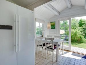 uma sala de jantar com uma mesa branca e cadeiras em Holiday Home Ottil - 1km from the sea in Sealand by Interhome em Tisvildeleje