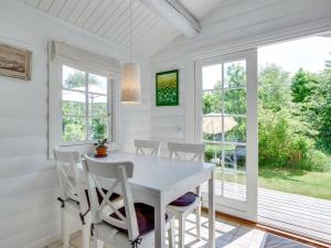 uma sala de jantar branca com uma mesa e cadeiras brancas em Holiday Home Ottil - 1km from the sea in Sealand by Interhome em Tisvildeleje