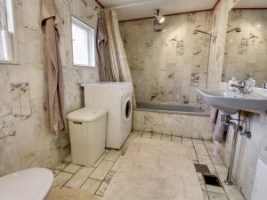 y baño con aseo, lavabo y lavadora. en Holiday Home Guthbrand - 900m from the sea in Sealand by Interhome, en Gilleleje