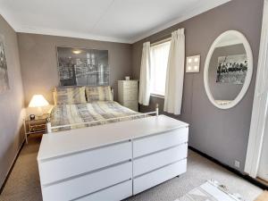 1 dormitorio con cama blanca y espejo en Holiday Home Guthbrand - 900m from the sea in Sealand by Interhome, en Gilleleje