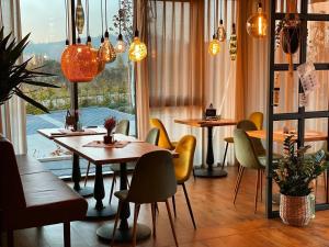 un restaurante con mesas y sillas y una ventana en Hotel Poellners 20 min von München Hbf, en Petershausen