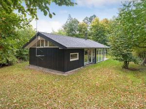 Ein schwarzes Haus mitten im Garten. in der Unterkunft Holiday Home Follerich - 250m from the sea in Sealand by Interhome in Gilleleje