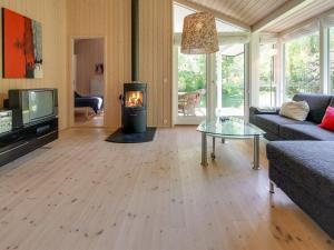 ein Wohnzimmer mit einem Holzofen in der Unterkunft Holiday Home Follerich - 250m from the sea in Sealand by Interhome in Gilleleje