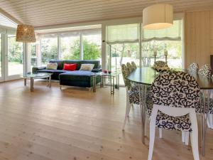ein Wohnzimmer mit einem Sofa, einem Tisch und Stühlen in der Unterkunft Holiday Home Follerich - 250m from the sea in Sealand by Interhome in Gilleleje