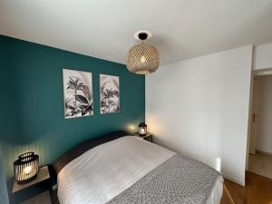 - une chambre avec un lit et deux photos sur le mur dans l'établissement L'escale du Trianon, au Plessis-Robinson