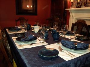 a table with plates and wine glasses on it at The Spaniards Room Heritage Home in Spaniards Bay