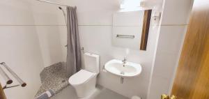 a white bathroom with a toilet and a sink at Hotel Pashos in Kriopigi +69 photos