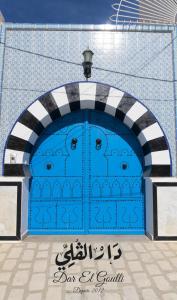 una puerta de garaje azul con un cartel delante en Dar El Goulli en Sousse