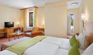 een hotelkamer met een bed en een woonkamer bij Hotel Liebl in Plattling