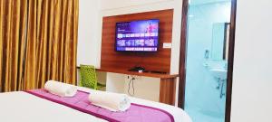 Keerthis Royal Suites - Near International Airport Terminal 1 and 2的电视和/或娱乐中心